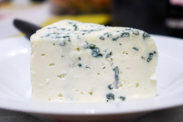 Beautiful wedge of blue cheese on a white dish